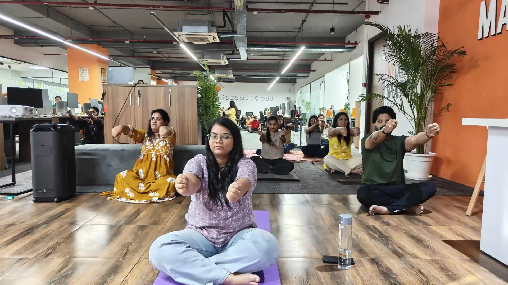 Global Survey Solutions team practicing seated yoga poses, Noida